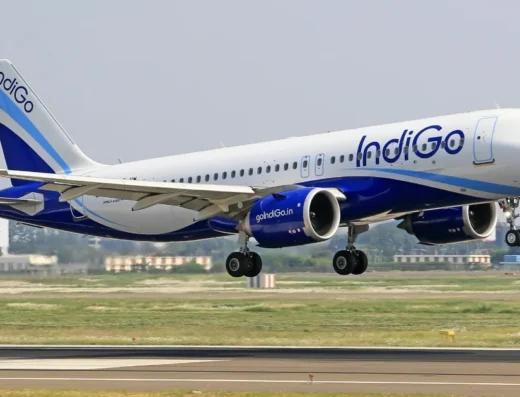 An IndiGo Airbus A320 aircraft on approach for landing, with its landing gear extended.