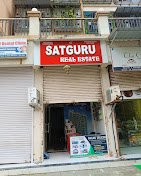 Satguru Real Estate Taloja entrance is visible in this image.